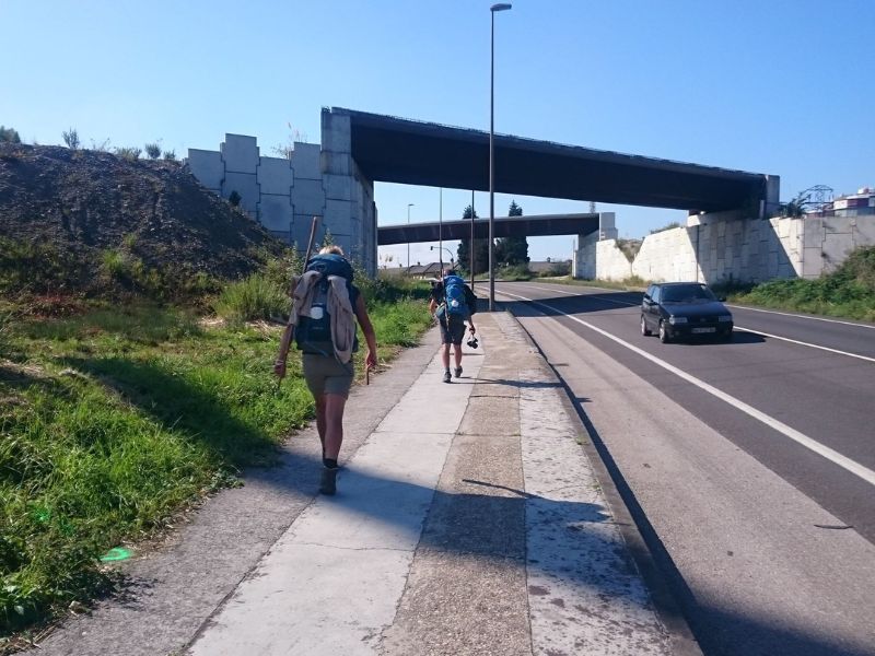 Pilger gehen ein Stück Asphaltstraße am Jakobsweg 20